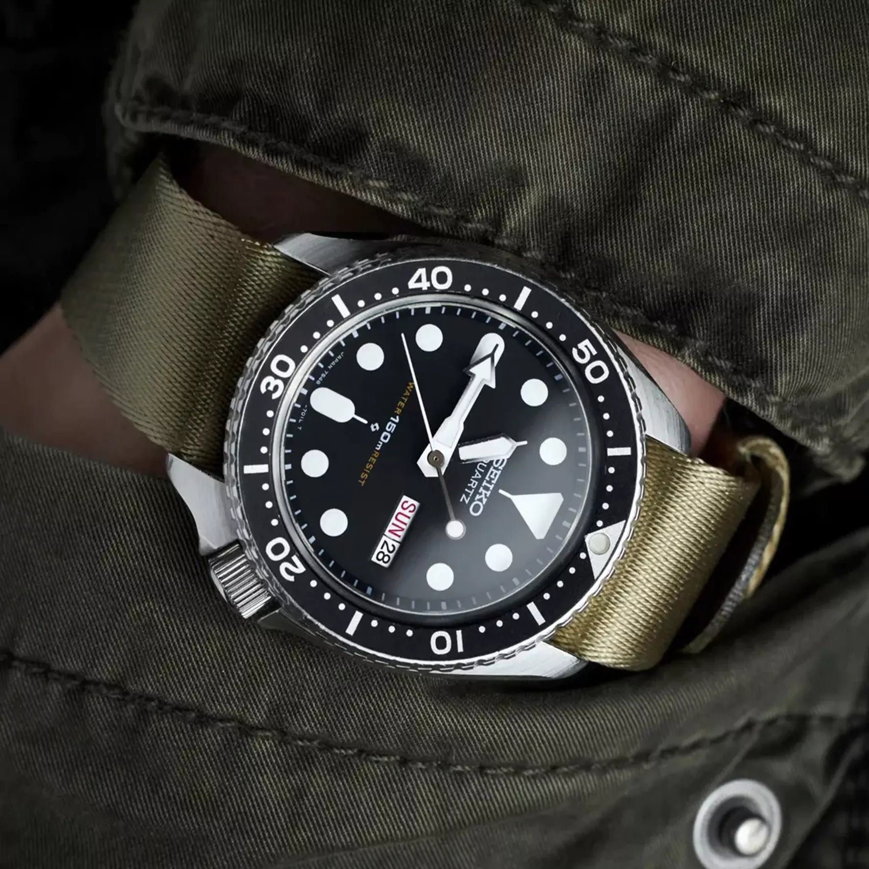Black watch pocket shot with khaki single-pass nylon strap