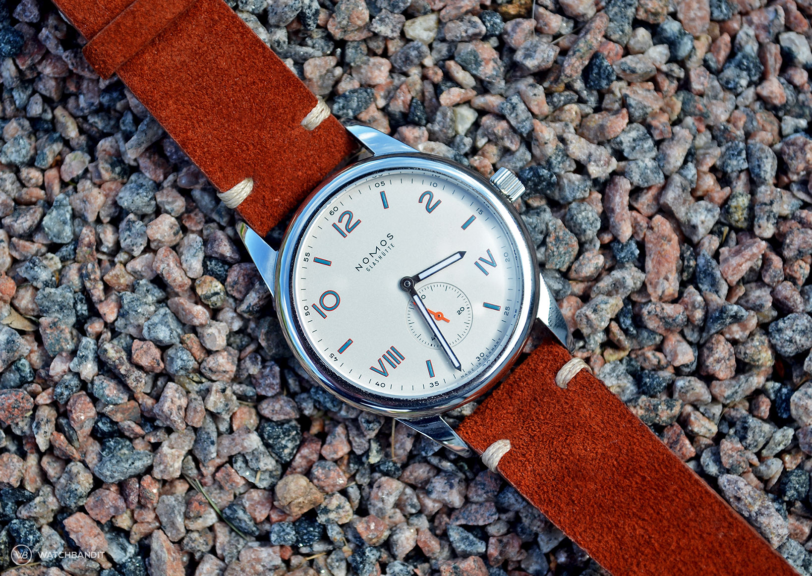 NOMOS Club Campus with rusty brown suede strap lying on stones by WB Original